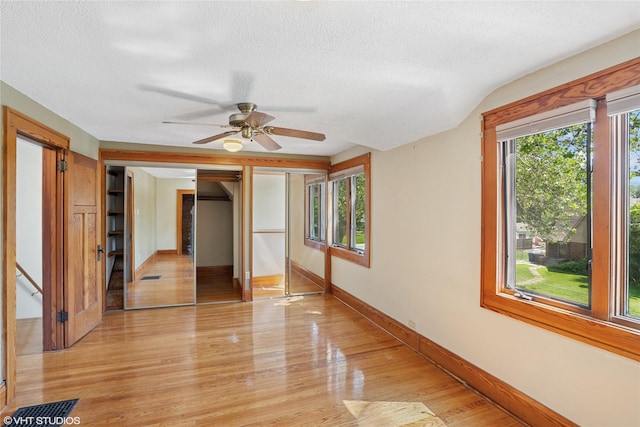 3320 SW 12th St, Des Moines, IA 50315 - unfurnished bedroom featuring multiple windows, a textured ceiling, light wood finished floors, and ceiling fan