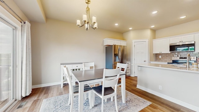 469 SE Hollow Ct, West Des Moines, IA 50265 - dining area featuring a chandelier, light wood-style flooring, and recessed lighting