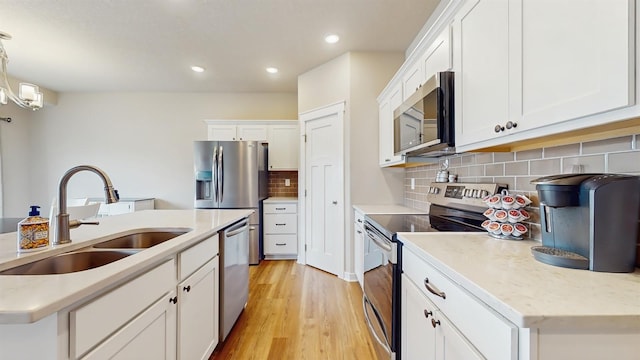 469 SE Hollow Ct, West Des Moines, IA 50265 - kitchen featuring stainless steel appliances, light wood-type flooring, white cabinetry, recessed lighting, and backsplash