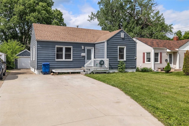 1428 E Tiffin Ave, Des Moines, IA 50316 - view of front of house featuring roof with shingles, a front lawn, an outdoor structure, and a garage