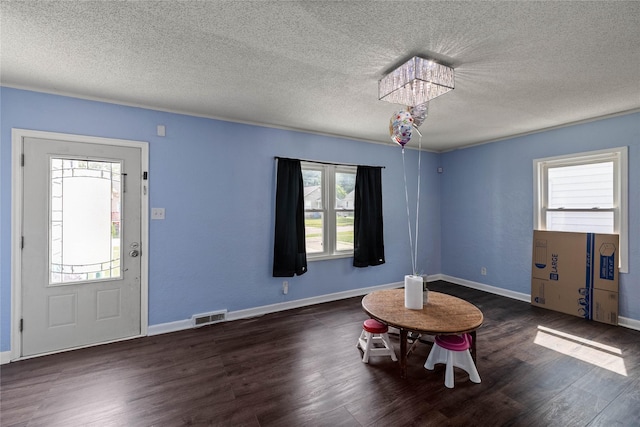1428 E Tiffin Ave, Des Moines, IA 50316 - foyer entrance featuring healthy amount of natural light, a chandelier, wood finished floors, and a textured ceiling