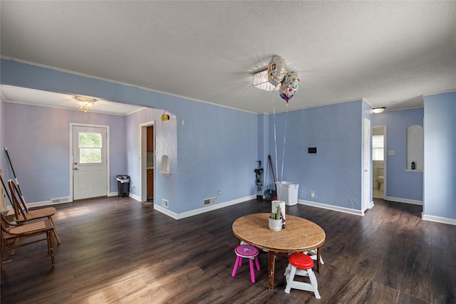1428 E Tiffin Ave, Des Moines, IA 50316 - living area with arched walkways, wood finished floors, crown molding, and a textured ceiling