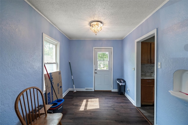 1428 E Tiffin Ave, Des Moines, IA 50316 - doorway with a textured ceiling, dark wood-type flooring, a textured wall, crown molding, and a chandelier