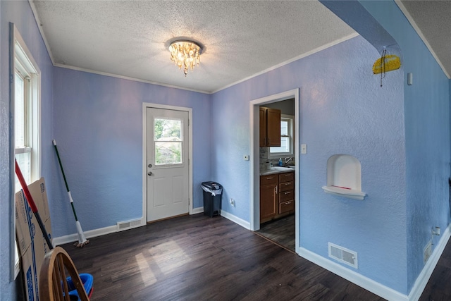 1428 E Tiffin Ave, Des Moines, IA 50316 - foyer entrance with a textured ceiling, a textured wall, ornamental molding, dark wood finished floors, and a chandelier