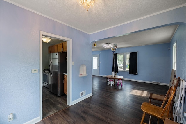 1428 E Tiffin Ave, Des Moines, IA 50316 - living area featuring arched walkways, a textured ceiling, dark wood finished floors, ornamental molding, and a textured wall