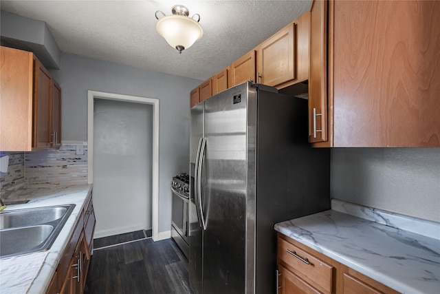 1428 E Tiffin Ave, Des Moines, IA 50316 - kitchen with dark wood-style flooring, stainless steel appliances, backsplash, a textured ceiling, and light stone countertops