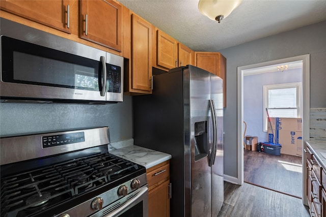 1428 E Tiffin Ave, Des Moines, IA 50316 - kitchen featuring stainless steel appliances, dark wood finished floors, and brown cabinetry