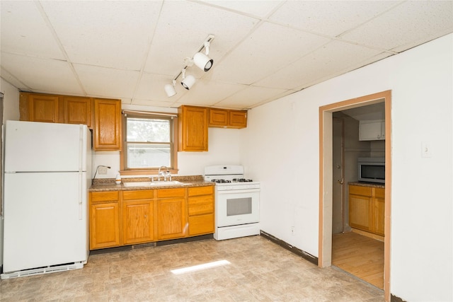 2420 Maple St, Des Moines, IA 50317 - kitchen featuring white appliances, a paneled ceiling, brown cabinets, and track lighting