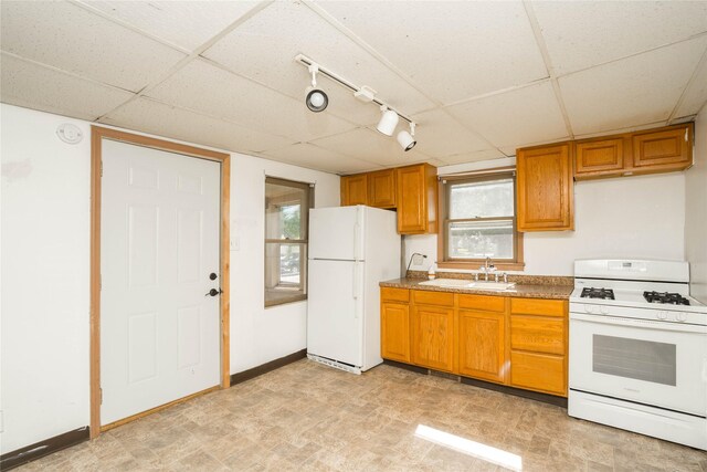 2420 Maple St, Des Moines, IA 50317 - kitchen featuring white appliances, a drop ceiling, brown cabinets, plenty of natural light, and rail lighting