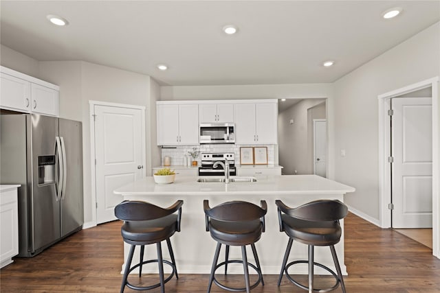 10525 Powell Ave, Johnston, IA 50131 - kitchen with stainless steel appliances, a kitchen breakfast bar, light countertops, white cabinets, and recessed lighting