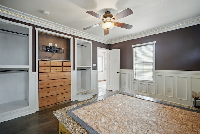 1519 E 30th St, Des Moines, IA 50317 - bedroom featuring a wainscoted wall, dark wood-style floors, crown molding, ceiling fan, and a decorative wall