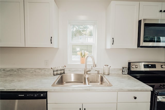 3405 30th St, Des Moines, IA 50310 - kitchen with stainless steel appliances, white cabinetry, and light countertops