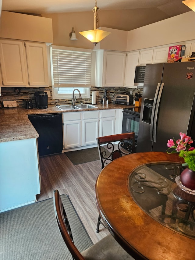 113 E 36th St, Des Moines, IA 50317 - kitchen with black appliances, white cabinetry, backsplash, dark wood-style flooring, and pendant lighting