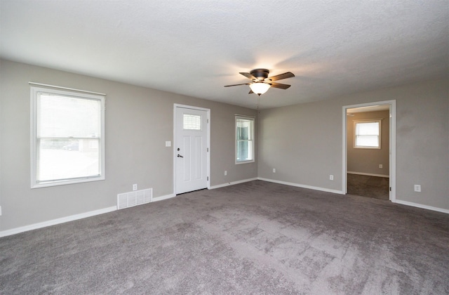 1012 28th St, Des Moines, IA 50311 - unfurnished living room with ceiling fan and carpet flooring