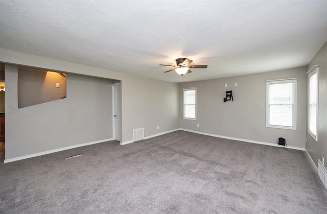 1012 28th St, Des Moines, IA 50311 - unfurnished room with a ceiling fan, dark carpet, and a textured ceiling
