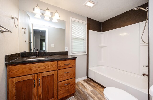 1012 28th St, Des Moines, IA 50311 - bathroom with wood finished floors, vanity, and shower / tub combination