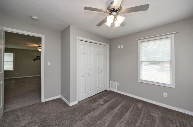 1012 28th St, Des Moines, IA 50311 - unfurnished bedroom featuring dark colored carpet, a closet, and a ceiling fan
