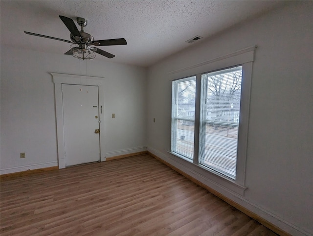 1418 E 9th St, Des Moines, IA 50316 - spare room featuring light wood finished floors, a textured ceiling, and a ceiling fan