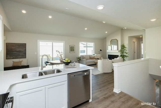 725 Linden St, Carlisle, IA 50047 - kitchen featuring appliances with stainless steel finishes, vaulted ceiling, white cabinetry, light wood finished floors, and light countertops