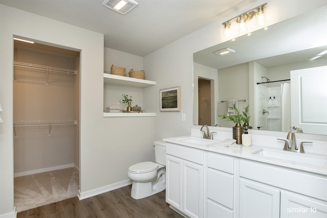 725 Linden St, Carlisle, IA 50047 - full bath with wood finished floors, double vanity, a walk in closet, and a shower