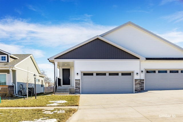 735 Linden St, Carlisle, IA 50047 - view of front of house with concrete driveway, stone siding, and a garage