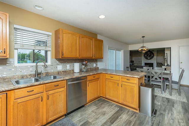 1205 Lancaster Way, Indianola, IA 50125 - kitchen with stainless steel dishwasher, light wood-style flooring, a peninsula, tasteful backsplash, and hanging light fixtures