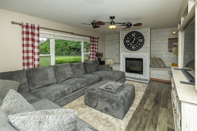 1205 Lancaster Way, Indianola, IA 50125 - living area with wood finished floors, a ceiling fan, a fireplace, and a textured ceiling