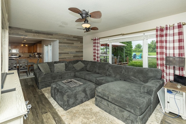 1205 Lancaster Way, Indianola, IA 50125 - living room featuring wood walls, dark wood-style floors, ceiling fan, and a textured ceiling