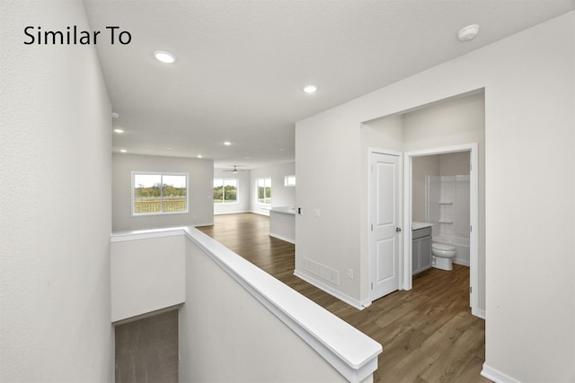 16732 Walnut Meadows Cir, Urbandale, IA 50323 - hallway with wood finished floors, recessed lighting, and an upstairs landing