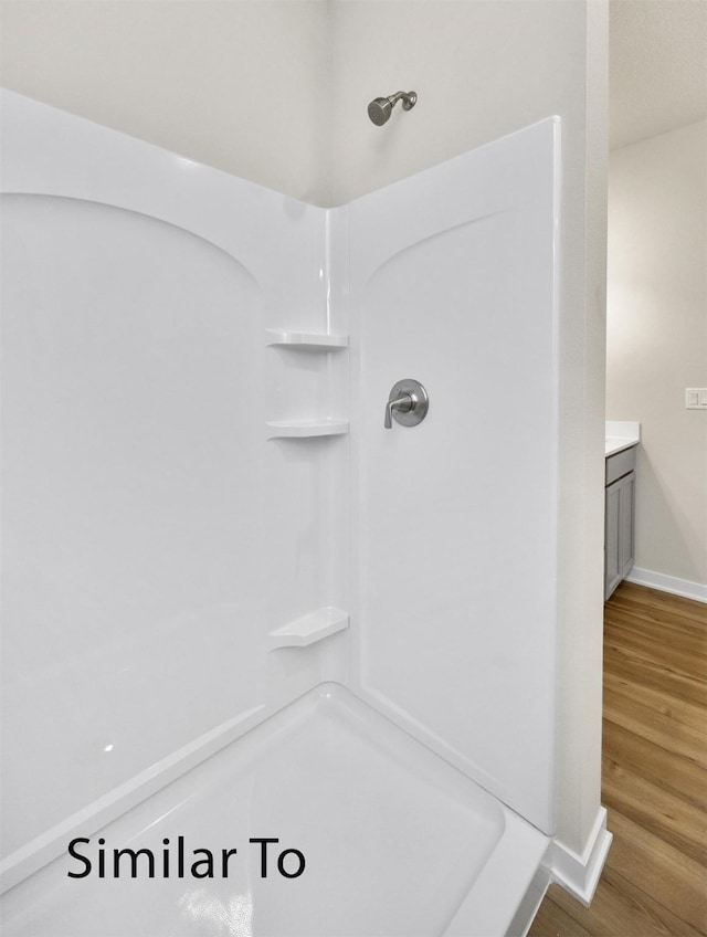 16738 Walnut Meadows Cir, Urbandale, IA 50323 - bathroom with wood finished floors, a shower, and vanity