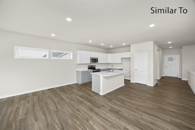 16738 Walnut Meadows Cir, Urbandale, IA 50323 - kitchen featuring appliances with stainless steel finishes, dark wood-type flooring, a center island with sink, light countertops, and recessed lighting