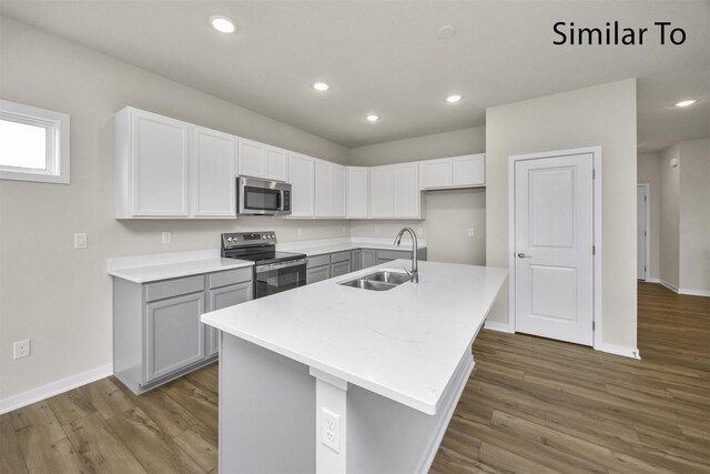 16738 Walnut Meadows Cir, Urbandale, IA 50323 - kitchen with stainless steel appliances, wood finished floors, light countertops, a center island with sink, and recessed lighting