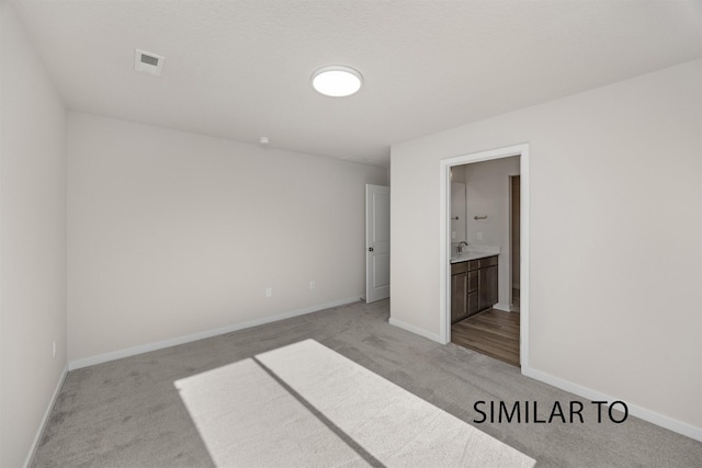 2212 Legacy Dr, Norwalk, IA 50211 - unfurnished bedroom featuring light carpet and ensuite bathroom