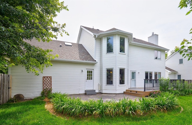 2216 NW 136th St, Clive, IA 50325 - rear view of house with a chimney, a patio, a wooden deck, and roof with shingles