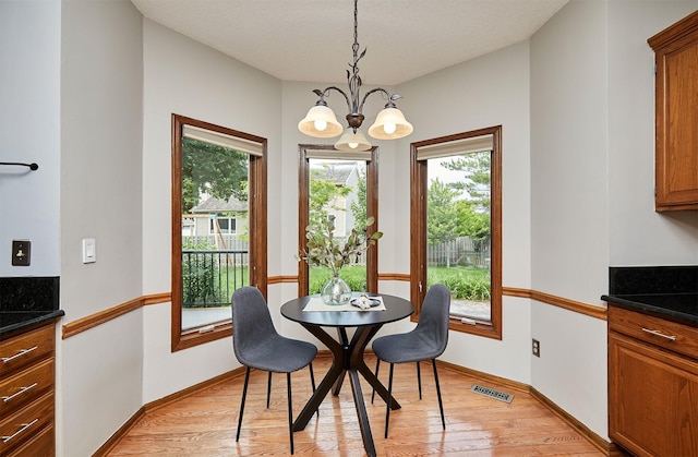 2216 NW 136th St, Clive, IA 50325 - dining area with a chandelier, plenty of natural light, and light wood-type flooring