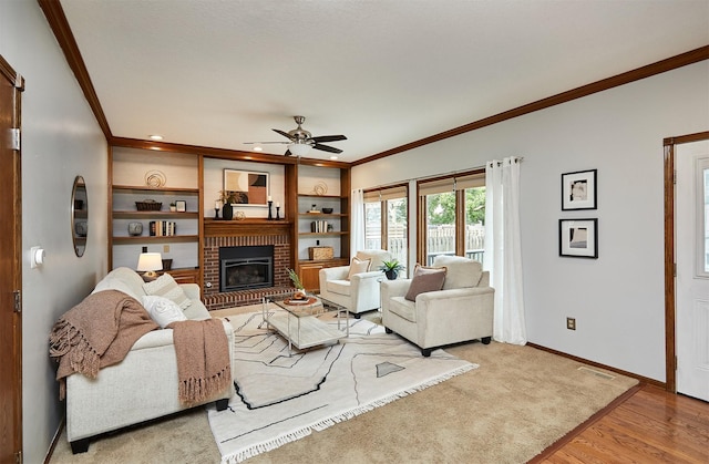 2216 NW 136th St, Clive, IA 50325 - living room with ornamental molding, a ceiling fan, a fireplace, light wood-style floors, and built in shelves