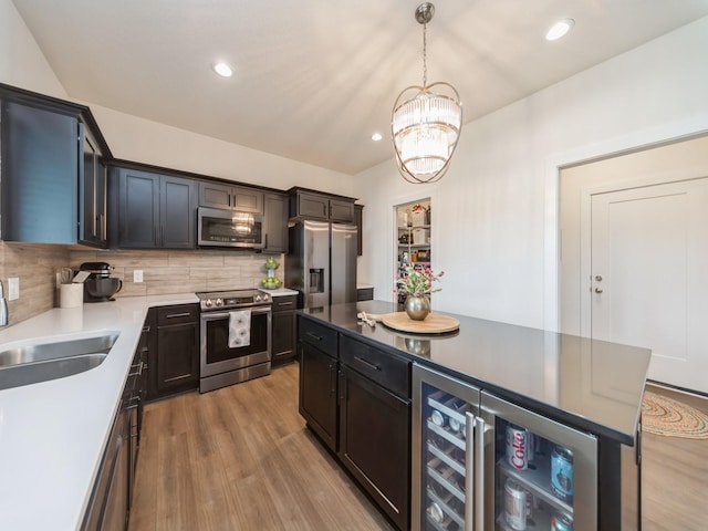 2502 Blooming Heights Dr, Norwalk, IA 50211 - kitchen featuring stainless steel appliances, wine cooler, backsplash, light wood finished floors, and a chandelier