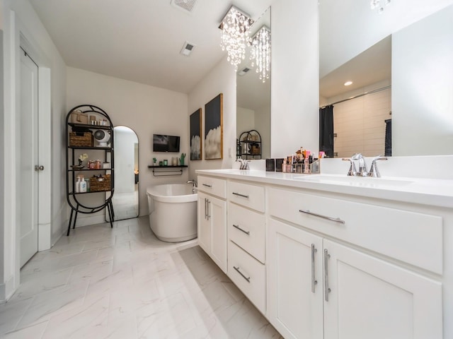 2502 Blooming Heights Dr, Norwalk, IA 50211 - full bathroom with double vanity, a freestanding bath, a chandelier, marble finish floors, and a shower