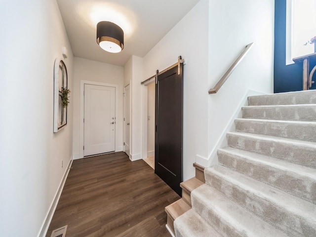 2502 Blooming Heights Dr, Norwalk, IA 50211 - doorway featuring stairway, a barn door, and dark wood-type flooring