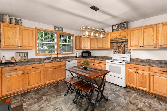 1334 E 13th St, Des Moines, IA 50316 - kitchen with white appliances, under cabinet range hood, dark countertops, and hanging light fixtures