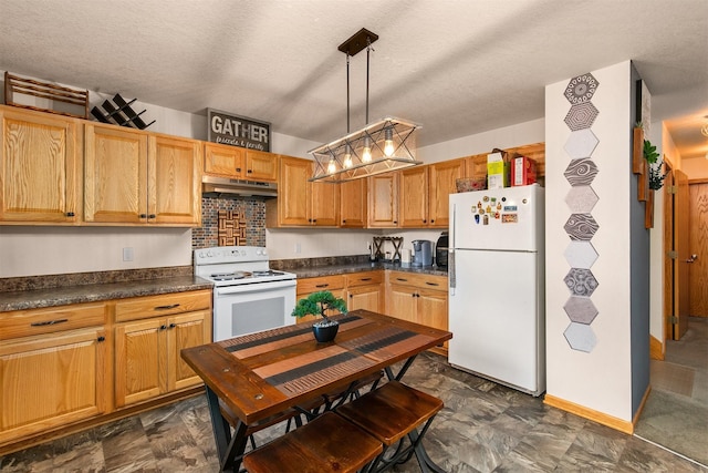 1334 E 13th St, Des Moines, IA 50316 - kitchen with white appliances, under cabinet range hood, dark countertops, decorative light fixtures, and a textured ceiling