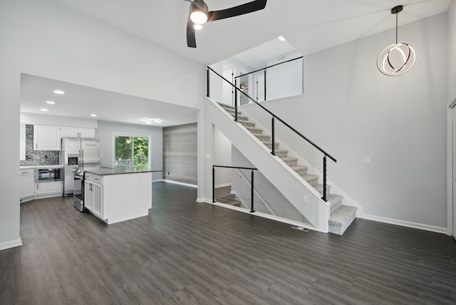 4510 89th St, Urbandale, IA 50322 - unfurnished living room with a ceiling fan, dark wood-type flooring, stairs, recessed lighting, and a high ceiling