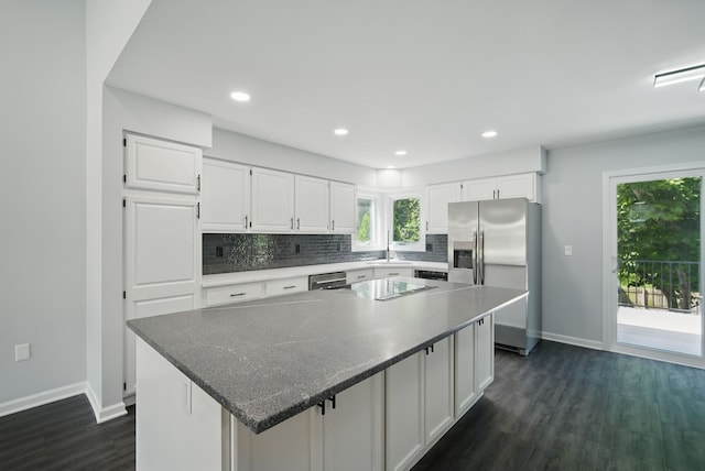 4510 89th St, Urbandale, IA 50322 - kitchen with appliances with stainless steel finishes, dark wood-style flooring, decorative backsplash, white cabinetry, and healthy amount of natural light