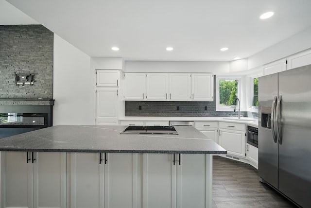 4510 89th St, Urbandale, IA 50322 - kitchen with stainless steel appliances, decorative backsplash, a kitchen island, white cabinetry, and recessed lighting