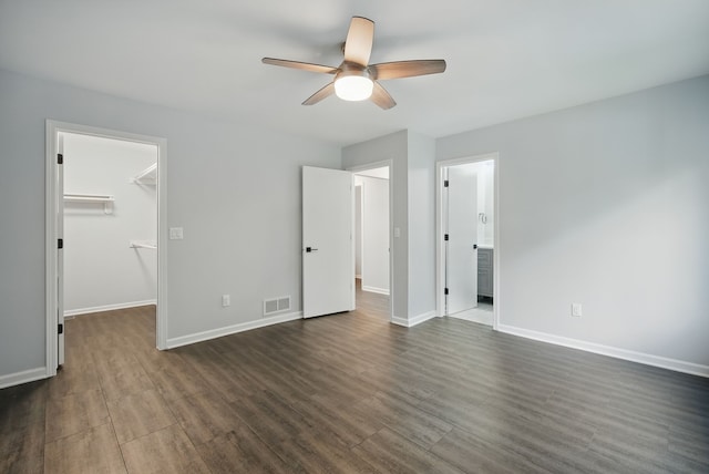 4510 89th St, Urbandale, IA 50322 - unfurnished bedroom featuring a spacious closet, dark wood finished floors, a ceiling fan, a closet, and ensuite bathroom