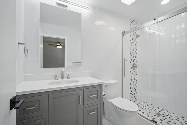 4510 89th St, Urbandale, IA 50322 - bathroom with tile walls, vanity, a shower stall, and a ceiling fan