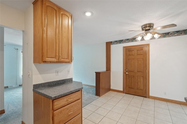2441 Hull Ave, Des Moines, IA 50317 - kitchen featuring a ceiling fan, dark countertops, and light colored carpet