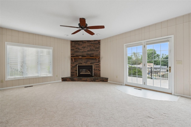 2441 Hull Ave, Des Moines, IA 50317 - unfurnished living room with ceiling fan, carpet flooring, and a brick fireplace