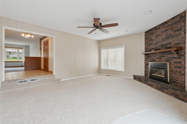 2441 Hull Ave, Des Moines, IA 50317 - unfurnished living room with carpet flooring, a ceiling fan, and a fireplace