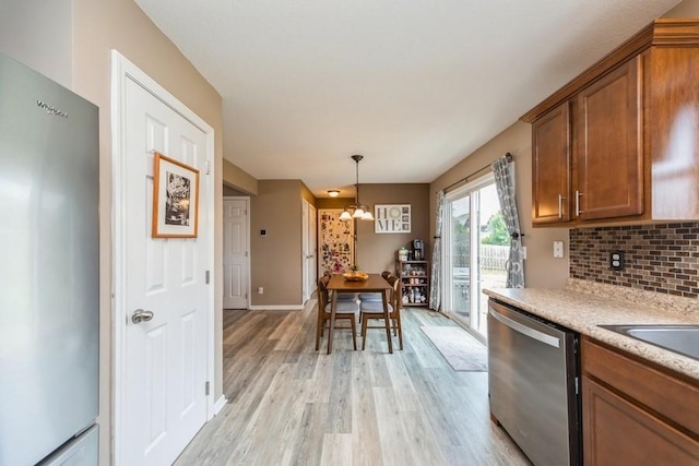 150 SE Hazelwood Dr, Waukee, IA 50263 - kitchen featuring stainless steel dishwasher, refrigerator, brown cabinets, and light wood-type flooring